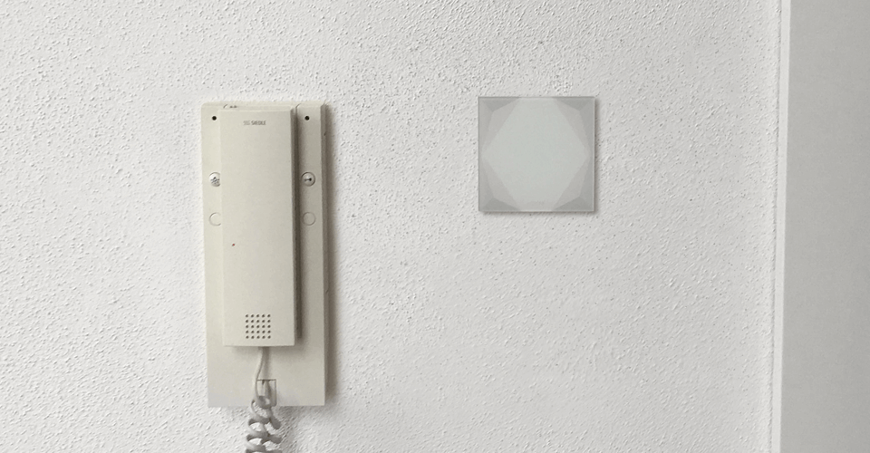 Chytré tlačítko Loxone Touch Pure vedle starého domovního telefonu