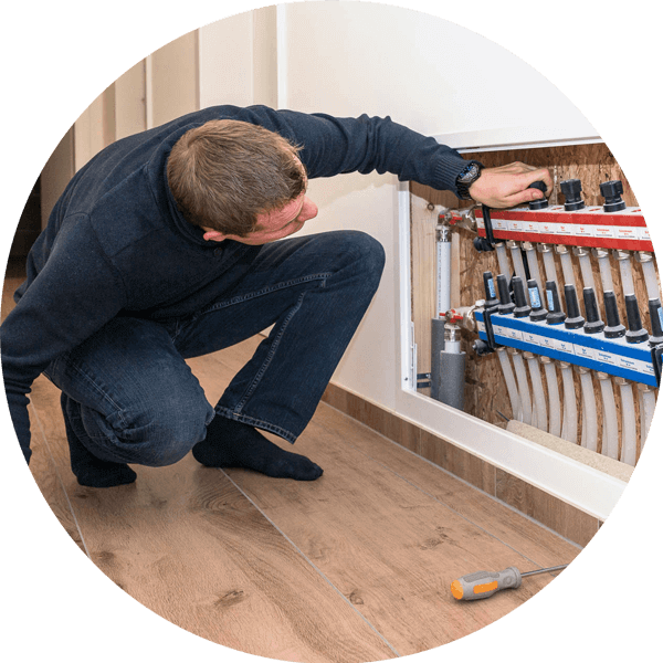 muž se snaží nastavit teplovodní podlahové vytápění domu