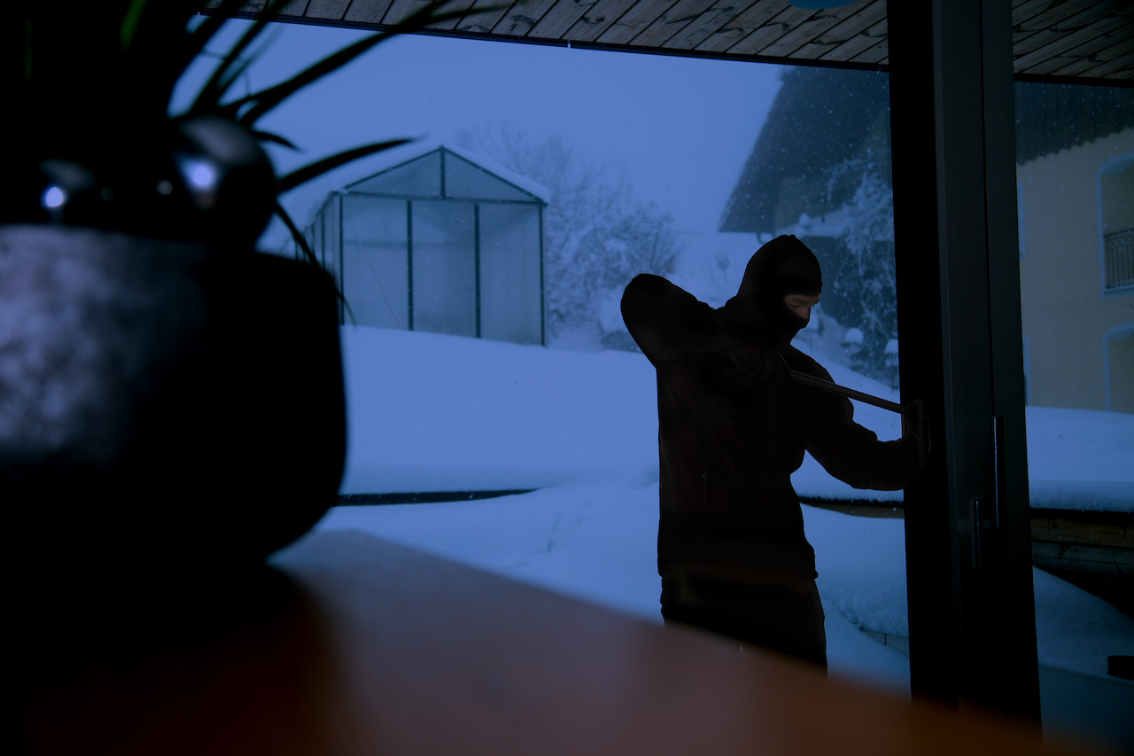 Zloděj snažící se vypáčit dveře