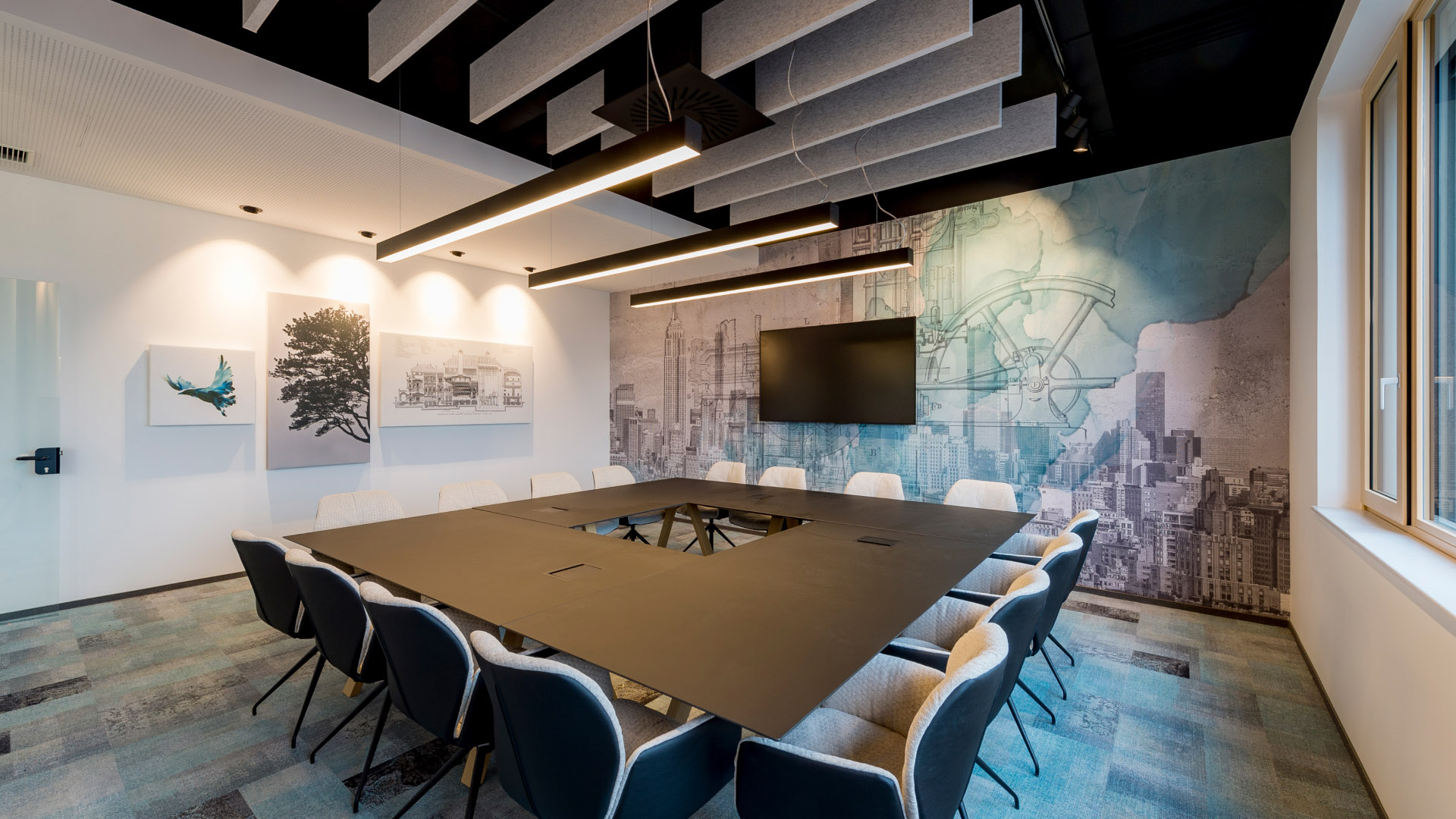 Na tomto obrázku je velká, moderní a designová zasedací místnost s velkým počtem míst k sezení