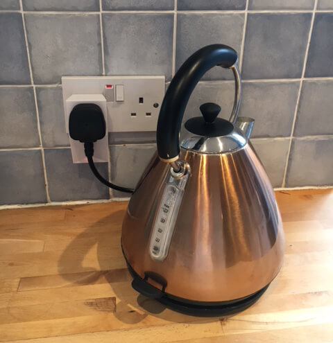 A kettle plugged into mains power through the Loxone Smart Socket Air