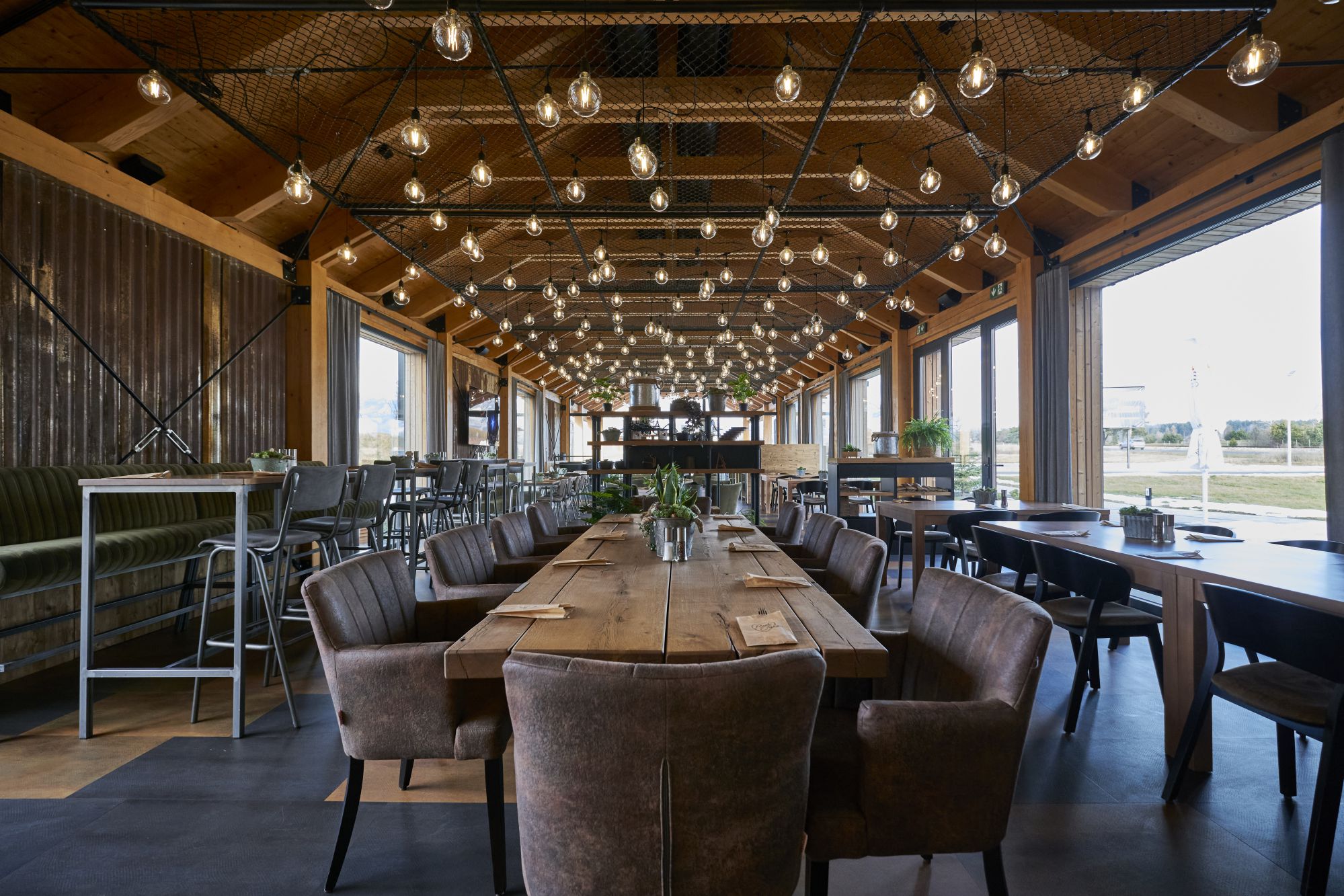 Blog-View-along-upstairs-of-restaurant Continuing the rustic theme there are retro bulb lights and metal mesh. Great views out the big windows.