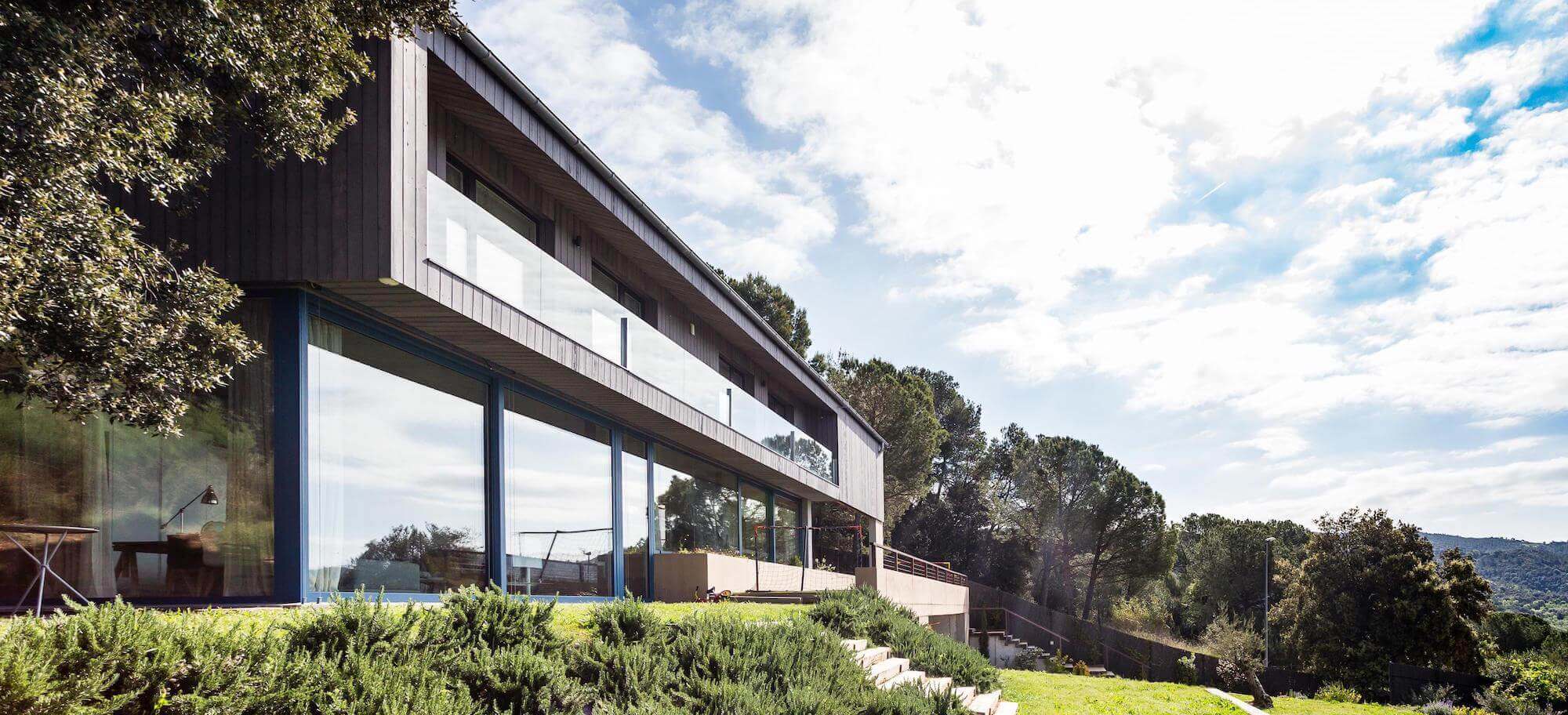 Exterior of Passive House Girona with bright sky.
