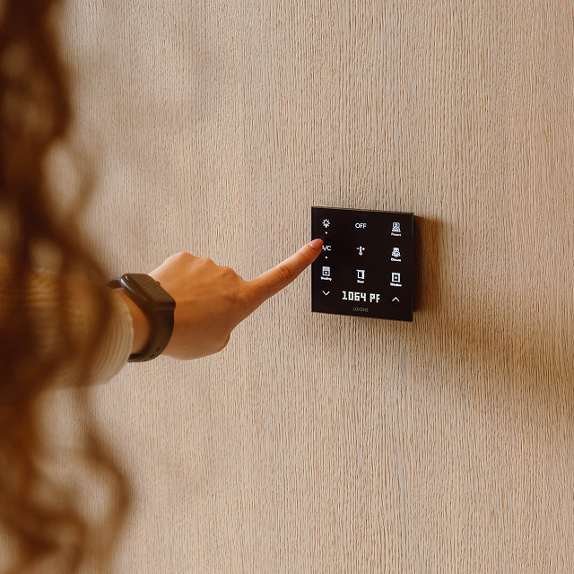 Frau bedient Touch Pure Flex CO2 an der Wand