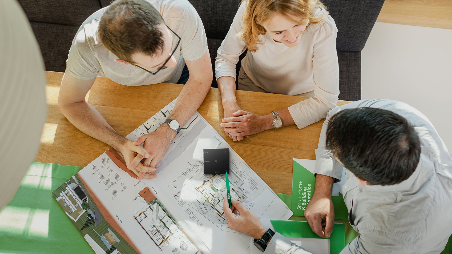 A picture showing a couple. The two are getting advice from a man regarding intelligent building automation.