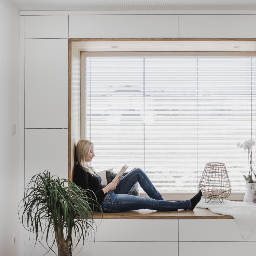 Frau vor einem Fenster im Smart Home.