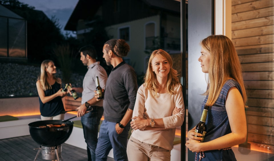 Een groep vrienden op een barbecue in de tuin.