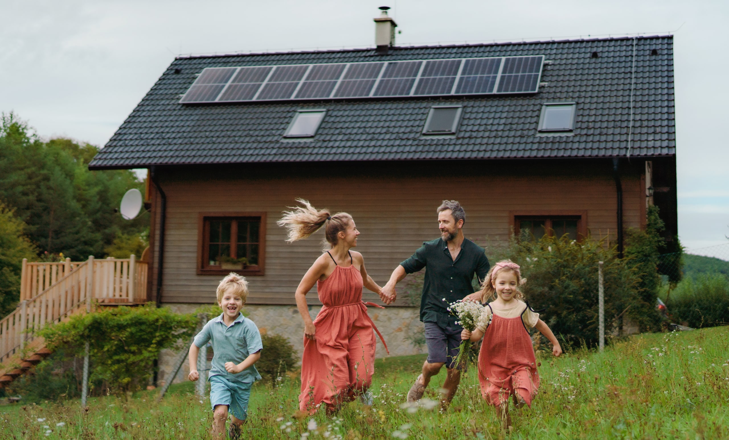 Rodzina biegnąca w ogrodzie przy domu