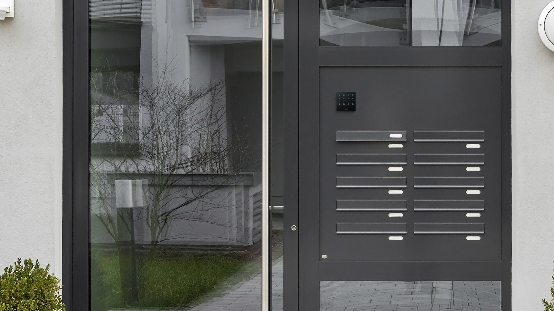 Touch Pure Flex Anthrazit an der Eingangstür zu einem Wohngebäude